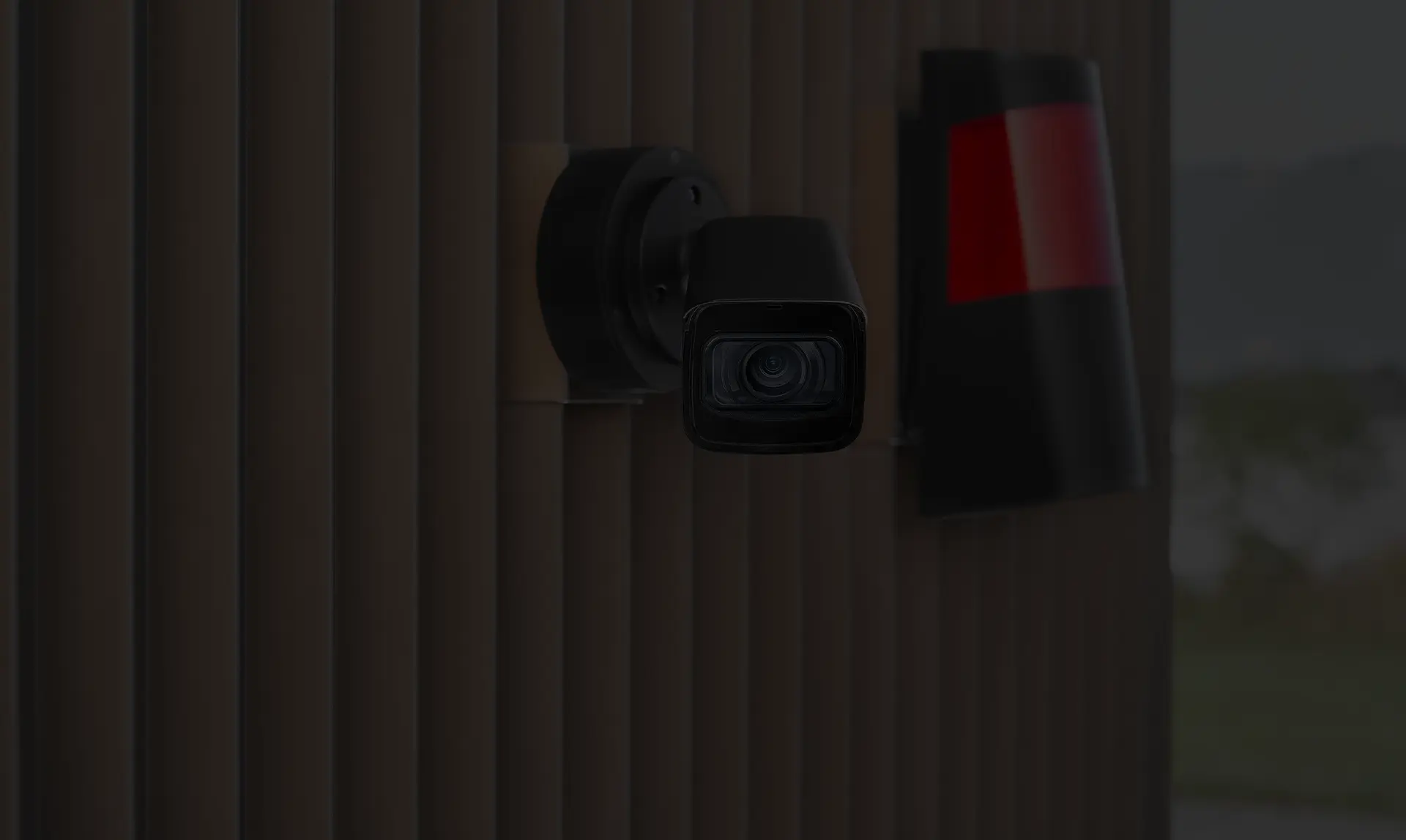 Eine Videokamera mit einer Alarmanlage außerhalb einer Gebäudewand.